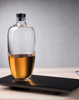 Bottiglia di whisky di malto alta con vassoio in legno