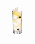 NUDE Caldera highball glass, with a v-shaped heavy bottom, presented with a soft yellow cocktail mix on a white background