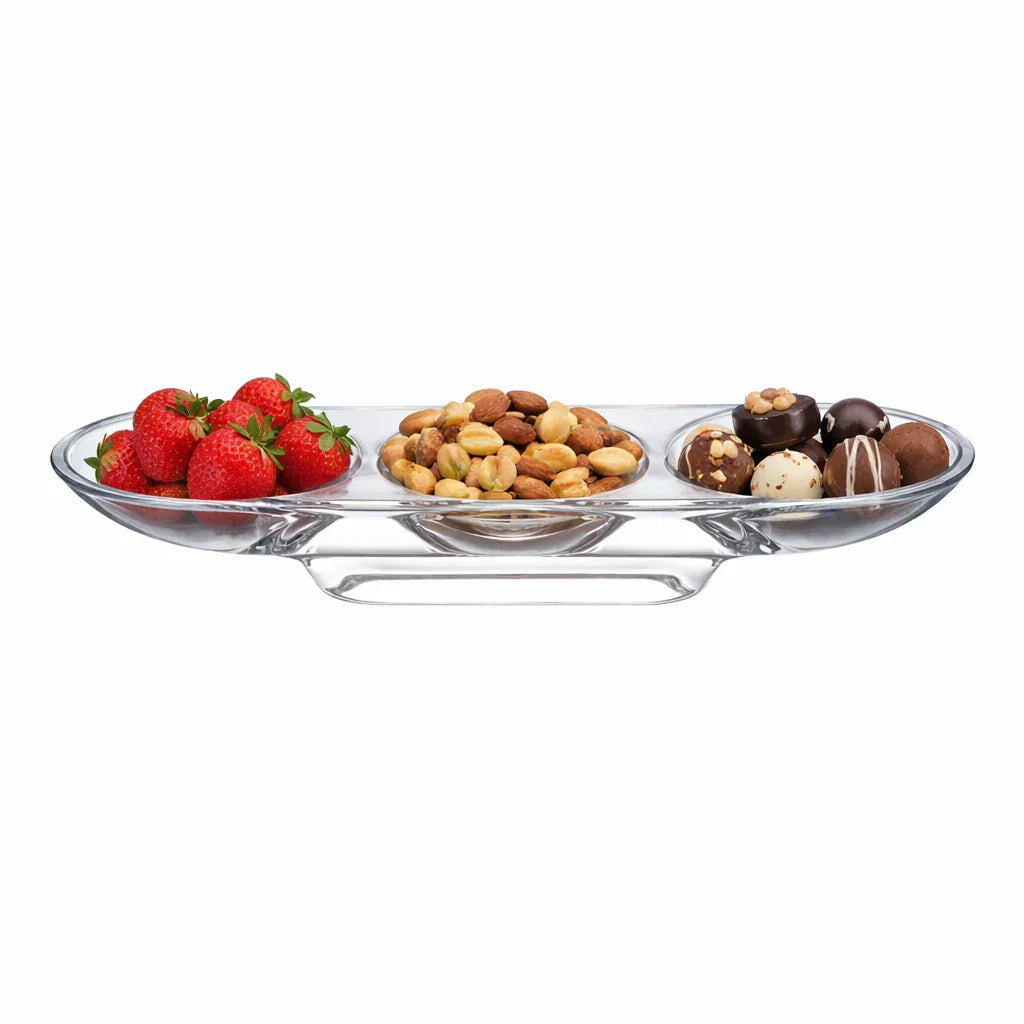 Clear glass appetizer tray with strawberries, nuts, and chocolates on a white background