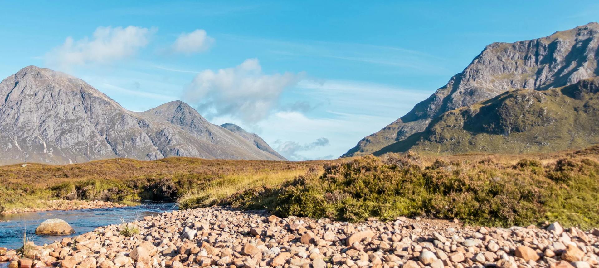 Scenic view of mountains and a river with rocky foreground