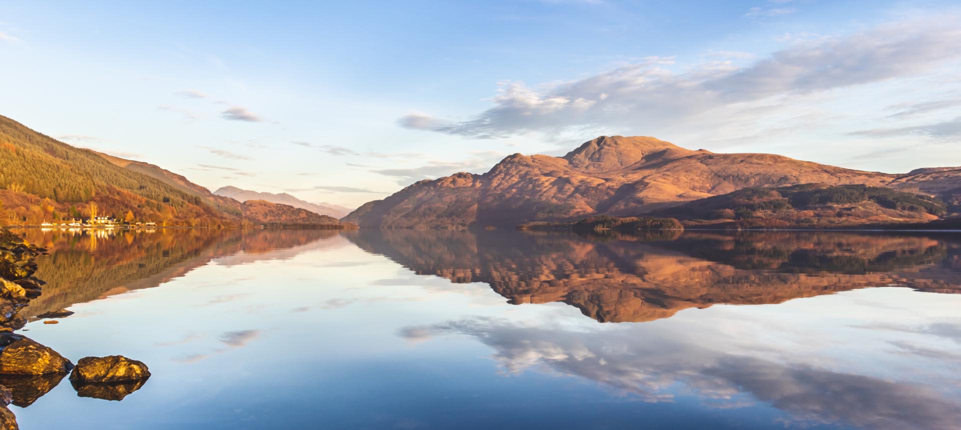 Mountain landscape with a lake reflecting the mountains and sky.