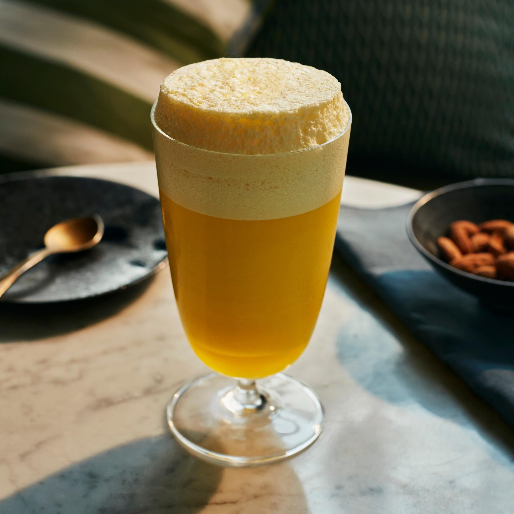 NUDE Bar/Giani Cocktail Glass Long with a foamy sour.