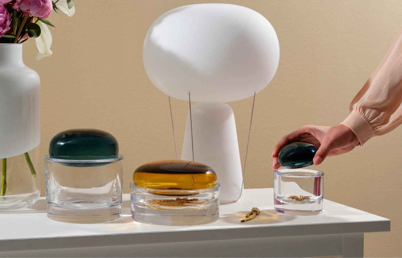  NUDE Ecrin Storage Boxes in teal and amber holding jewellery beside a white Magnolia Vase and Blow lamp.