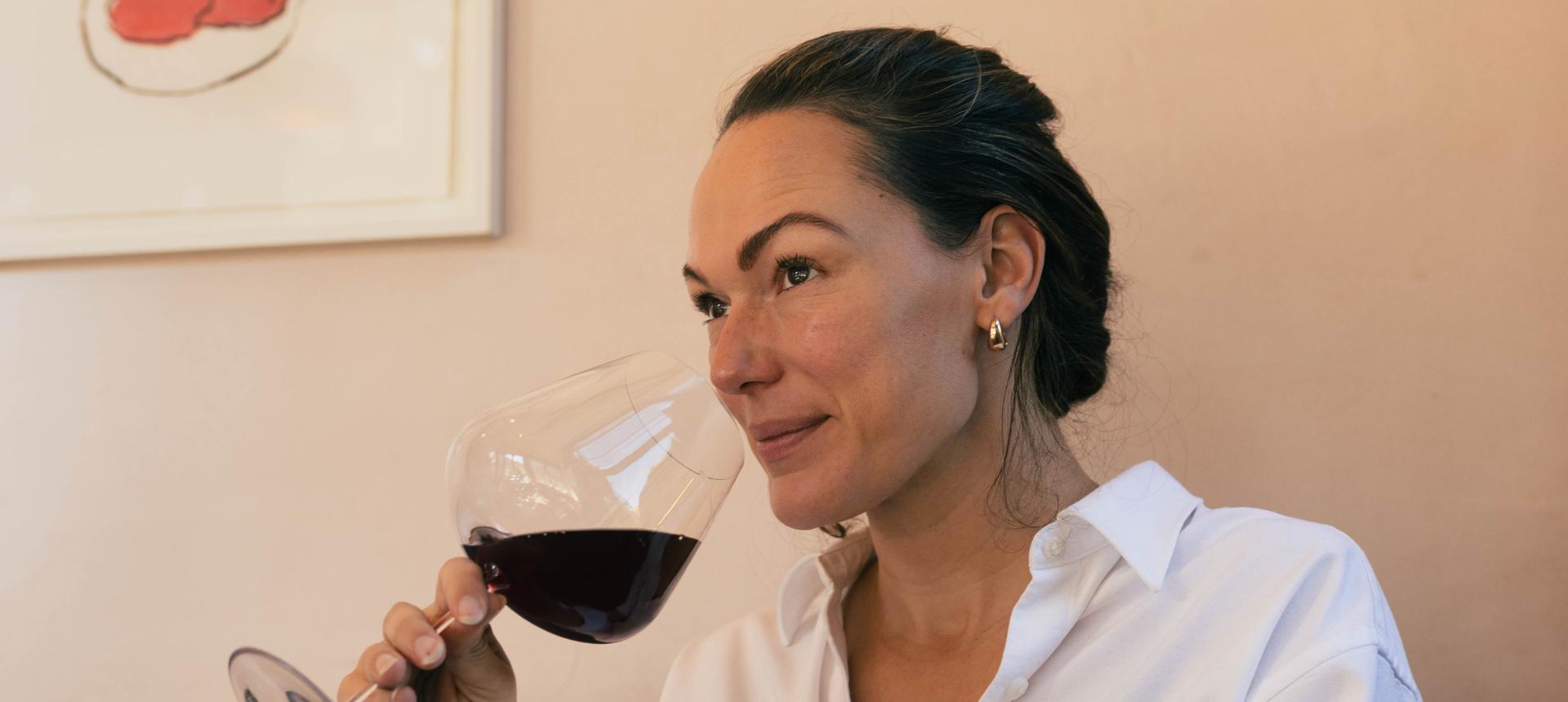 Sommelier Honey Spencer nosing red wine from a NUDE Stem Zero red wine glass