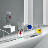Lifestyle image of NUDE Rock & Pop glass collection with jug, highball glass and whisky glass in light neon environment
