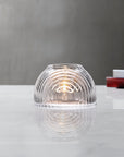 Lead-free crystal dome shaped votive with a rippled design, presented with votive on a table