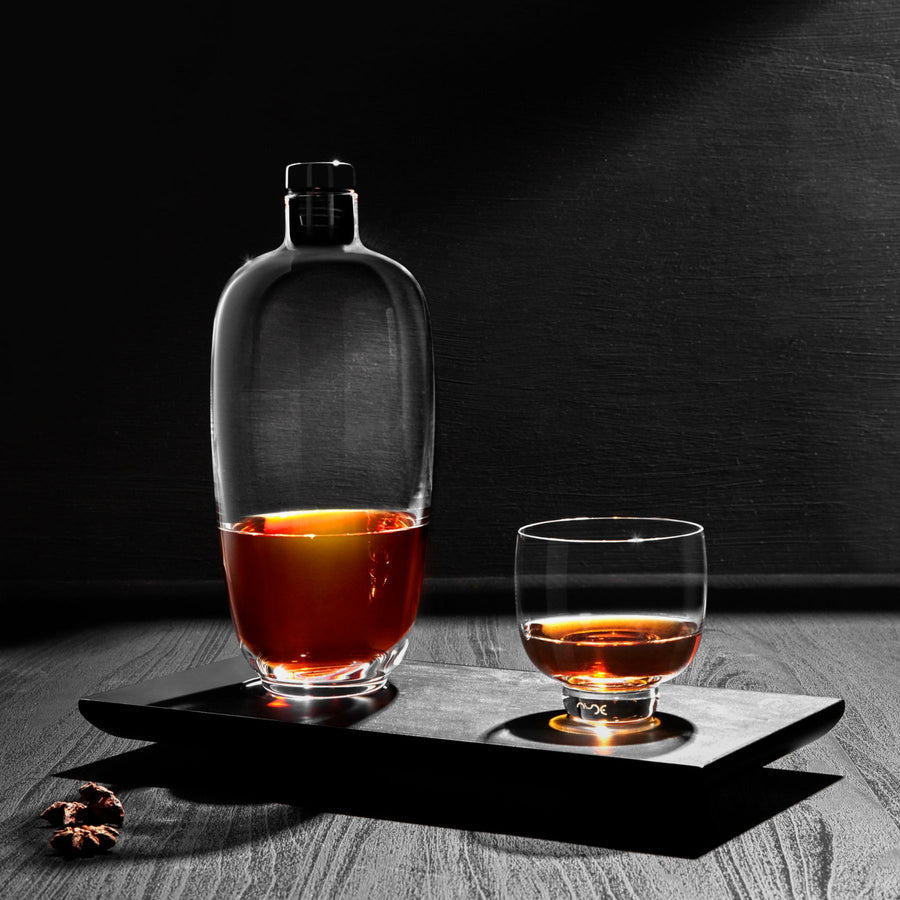 Bottiglia di whisky di malto alta con vassoio in legno