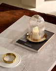 Lead-free crystal candle holder Ilo in small, a dome shaped candle holder with rippled glass effect, with candle presented on a table with some books and a small rippled tray in a dome shape